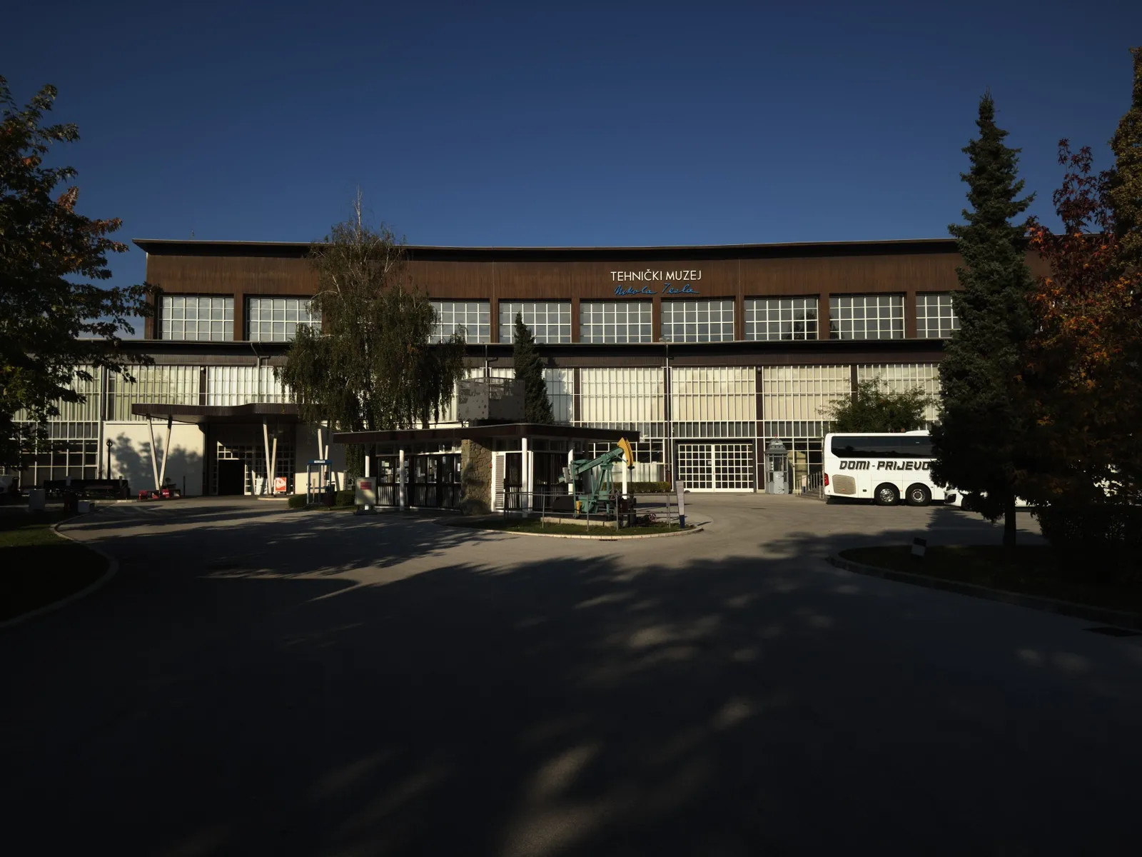 El patio del museo con la bomba de petróleo y un ómnibus estacionado